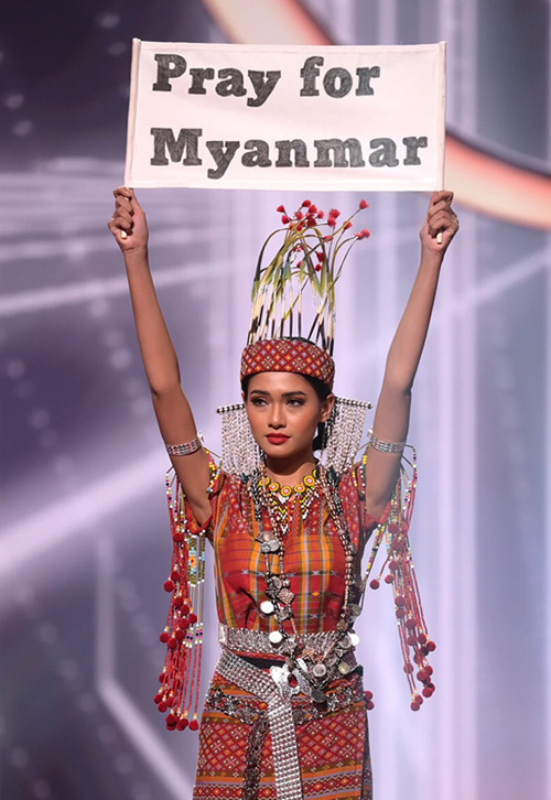 Thuzar Wint Lwin giơ biểu ngữ trong phần thi trang phục dân tộc tại Miss Universe 2020. Ảnh: MU.